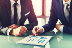 dois executivos na mesa com graficos