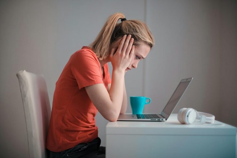 Mulher desanimada em frente a notebook Rejeição 212