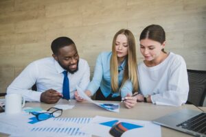 Três pessoas analisando gráficos da rejeição 230