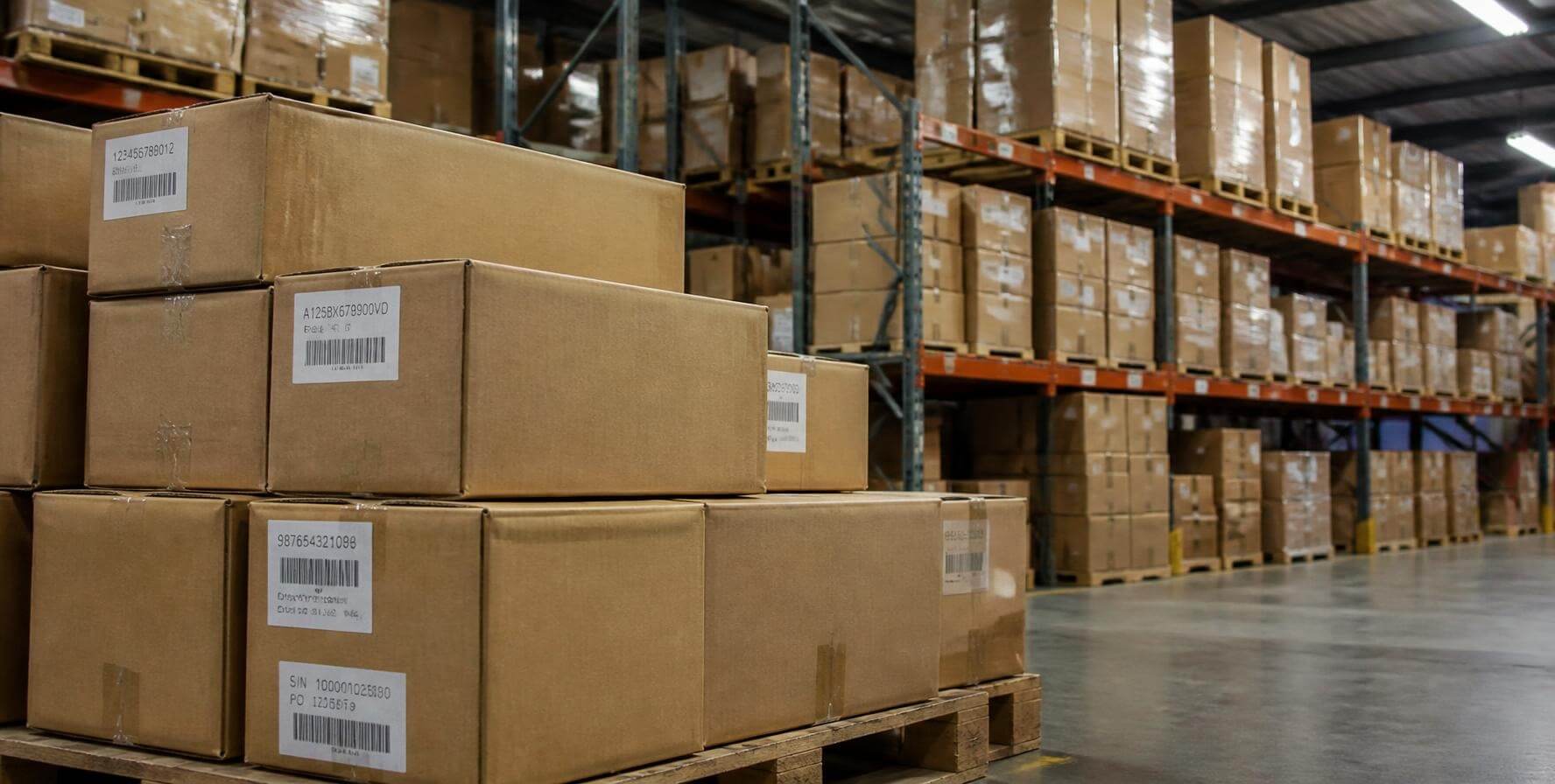 Caixas com etiquetas de código de barras em paletes e prateleiras de um depósito