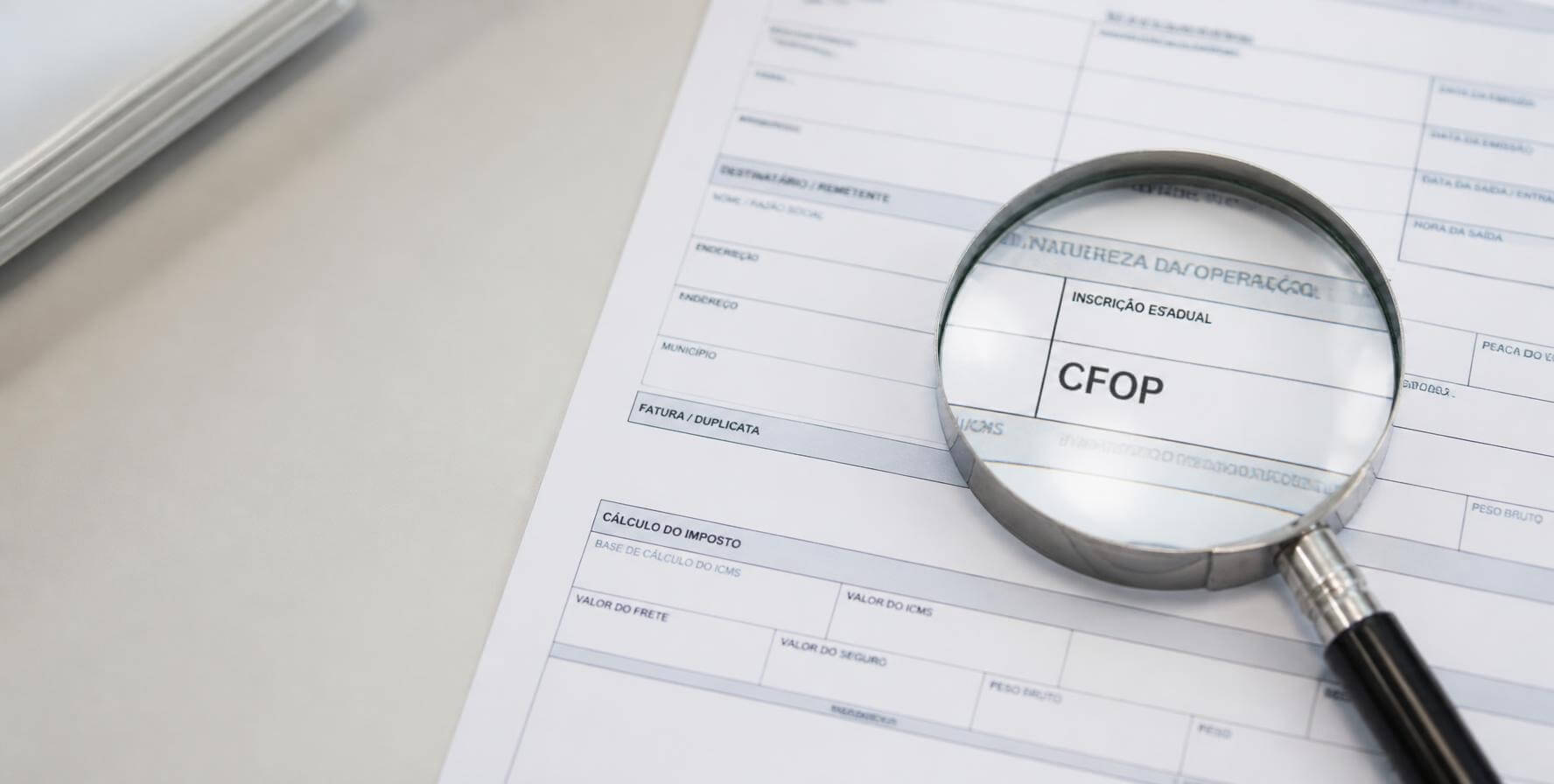 Lupa destacando o campo CFOP em uma nota fiscal impressa